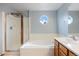 Bright bathroom featuring a soaking tub, a separate glass-enclosed shower, and window at 5596 S Urban St, Littleton, CO 80127