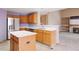 Bright kitchen with light wood cabinets, island, and stainless steel appliances at 5596 S Urban St, Littleton, CO 80127