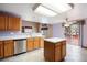 Kitchen with island, stainless dishwasher and sink, lots of storage, and bright lighting at 5596 S Urban St, Littleton, CO 80127