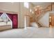 Open living room featuring high ceilings, a staircase, large windows, and neutral tones at 5596 S Urban St, Littleton, CO 80127