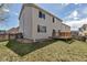 Back of a house with a small backyard deck, grass, and a fence at 19593 E Hollow Creek Dr, Parker, CO 80134