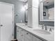 Bathroom featuring double sinks, white cabinets, quartz countertops and nice mirrors at 19593 E Hollow Creek Dr, Parker, CO 80134