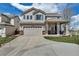 Charming two-story home with a well-manicured lawn, inviting front porch, and attached two-car garage at 19593 E Hollow Creek Dr, Parker, CO 80134