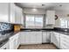 White kitchen with granite countertops, tiled backsplash, and stainless steel dishwasher at 19593 E Hollow Creek Dr, Parker, CO 80134