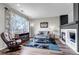 Bright living room featuring a fireplace, large window, and stylish decor at 19593 E Hollow Creek Dr, Parker, CO 80134