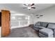 Open living room with neutral walls, plush carpet, ceiling fan, and chandelier at 19593 E Hollow Creek Dr, Parker, CO 80134