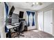 Modern office with mounted monitors, dark carpet and sliding door at 19593 E Hollow Creek Dr, Parker, CO 80134
