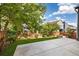 Lush backyard with well-maintained lawn, a cozy concrete patio, and vibrant green trees and landscaping at 6760 Mariposa Ct, Denver, CO 80221