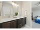 Modern bathroom with double vanity, white countertops, dark wood cabinets, and contemporary lighting fixtures at 6760 Mariposa Ct, Denver, CO 80221