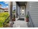 Inviting front porch with a railing, potted plants, space for seating, and an attractive front door at 6760 Mariposa Ct, Denver, CO 80221