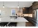 Modern kitchen with stainless steel appliances, a brick backsplash, and a large island at 6760 Mariposa Ct, Denver, CO 80221
