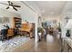 Inviting living room featuring hardwood floors, a piano, bookshelf, and a view into the adjacent living room at 6760 Mariposa Ct, Denver, CO 80221
