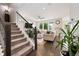Open-concept living room with a staircase and hardwood floors that includes views into other rooms at 6760 Mariposa Ct, Denver, CO 80221
