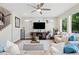 Bright living room featuring a ceiling fan, large windows and neutral tones at 6760 Mariposa Ct, Denver, CO 80221