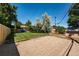 Spacious backyard featuring grass area and section with mulch, surrounded by a wood fence and mature trees at 4660 E Briarwood Pl, Centennial, CO 80122