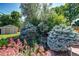 Serene backyard featuring mature trees, landscaping, pond with small waterfall, and a storage shed at 4660 E Briarwood Pl, Centennial, CO 80122