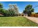 Large backyard with grass and small storage shed surrounded by privacy fence and mature trees at 4660 E Briarwood Pl, Centennial, CO 80122