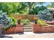 Landscaped backyard with steps leading to a stone patio with potted flowers at 4660 E Briarwood Pl, Centennial, CO 80122