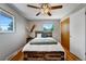 This bedroom features hardwood floors, neutral paint, two windows, and a ceiling fan for year-round comfort at 4660 E Briarwood Pl, Centennial, CO 80122