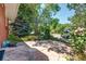 A stone patio with lush vegetation, colorful flowers, and a tree canopy at 4660 E Briarwood Pl, Centennial, CO 80122