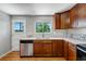 Cozy kitchen with wood cabinets, stainless steel dishwasher, and bright window at 4660 E Briarwood Pl, Centennial, CO 80122