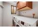 Well-equipped laundry room with a stacked washer and dryer and upper cabinets at 4660 E Briarwood Pl, Centennial, CO 80122