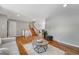 Open living room features hardwood floors, neutral paint, and entry to stairway and dining room at 4660 E Briarwood Pl, Centennial, CO 80122