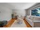 Cozy living room showcases plush seating, modern rug, hardwood flooring and a bright window at 4660 E Briarwood Pl, Centennial, CO 80122