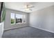 Comfortable bedroom with three windows offering natural light, ceiling fan, and neutral carpet flooring at 9772 Clairton Pl, Highlands Ranch, CO 80126