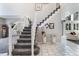 Elegant staircase with gray carpet steps and white banister, leading to the upper level of the home at 9772 Clairton Pl, Highlands Ranch, CO 80126