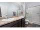 Bathroom featuring a double sink vanity, a large mirror, and a glass-enclosed shower with tile surround at 6055 Point Rider Cir, Castle Rock, CO 80104