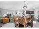 Inviting dining area adjacent to the kitchen and living room, featuring a chandelier and natural light at 6055 Point Rider Cir, Castle Rock, CO 80104