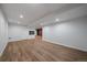 Open basement area featuring plank flooring, fireplace, and multiple access points at 1746 Shavano St, Longmont, CO 80504