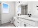 Modern bathroom with double sinks, white cabinetry, and a tiled shower for a clean, stylish look at 6845 Fawn Path Way, Castle Pines, CO 80108