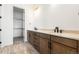 Modern bathroom featuring double vanity with wood cabinets, quartz countertop, and a walk-in closet at 6845 Fawn Path Way, Castle Pines, CO 80108
