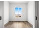Bedroom featuring hardwood floors, a window, and white walls with minimalist design and doors at 6845 Fawn Path Way, Castle Pines, CO 80108
