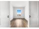 Bedroom featuring hardwood floors, a window, and white walls with minimalist design and doors at 6845 Fawn Path Way, Castle Pines, CO 80108