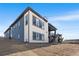 Modern two-story home with a combination of white brick and blue siding, large windows, and landscaped backyard at 6845 Fawn Path Way, Castle Pines, CO 80108
