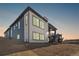 Modern two-story home with a combination of white brick and blue siding, large windows, and landscaped backyard at 6845 Fawn Path Way, Castle Pines, CO 80108