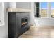 Modern fireplace with a sleek design and a cozy ambiance, complemented by a large window and hardwood floors at 6845 Fawn Path Way, Castle Pines, CO 80108