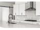 Close up on modern kitchen with white cabinets, quartz countertops, and herringbone backsplash at 6845 Fawn Path Way, Castle Pines, CO 80108
