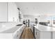 Modern kitchen with white cabinets, marble countertops, stainless steel appliances, and herringbone backsplash at 6845 Fawn Path Way, Castle Pines, CO 80108