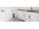 Well-equipped laundry room with modern cabinetry, a utility sink, and stylish patterned flooring at 6845 Fawn Path Way, Castle Pines, CO 80108