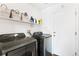 Modern laundry room with front loading washer and dryer and plenty of storage at 19430 E 58Th Dr, Aurora, CO 80019