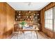 Inviting home office featuring built-in shelving, wood-paneled walls, and natural light, creating a warm and productive workspace at 6211 W Fremont Pl, Littleton, CO 80128