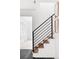 Modern staircase showcasing a sleek black railing, light wood steps, and bright white walls, offering a clean aesthetic at 6211 W Fremont Pl, Littleton, CO 80128