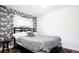 Stylish bedroom with a unique wallpaper accent wall and comfortable furnishings at 2401 E 35Th Ave, Denver, CO 80205