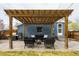 Backyard brick patio with pergola, outdoor seating, grill, and black privacy fence at 2401 E 35Th Ave, Denver, CO 80205