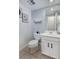 Well-lit half bathroom with a modern toilet, a vanity sink, and a wall mirror, maximizing space and functionality at 14120 E Warren Pl, Aurora, CO 80014