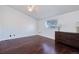 Bright bedroom featuring hardwood floors, window and dresser with decor lamps at 14120 E Warren Pl, Aurora, CO 80014